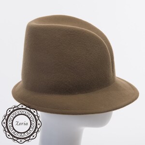 May include: A brown felt fedora hat with a wide brim. The hat is on a white mannequin head.