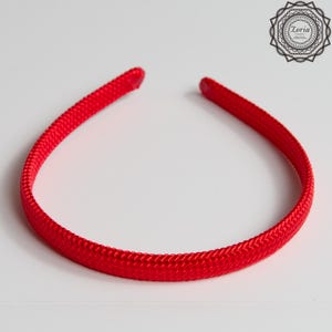 Pu&ograve; includere: Una fascia per capelli rosso brillante con una trama intrecciata. La fascia forma un anello continuo, progettata per essere indossata intorno alla testa. L'accessorio &egrave; di colore pieno e vivace, adatto a vari acconciature e occasioni.
