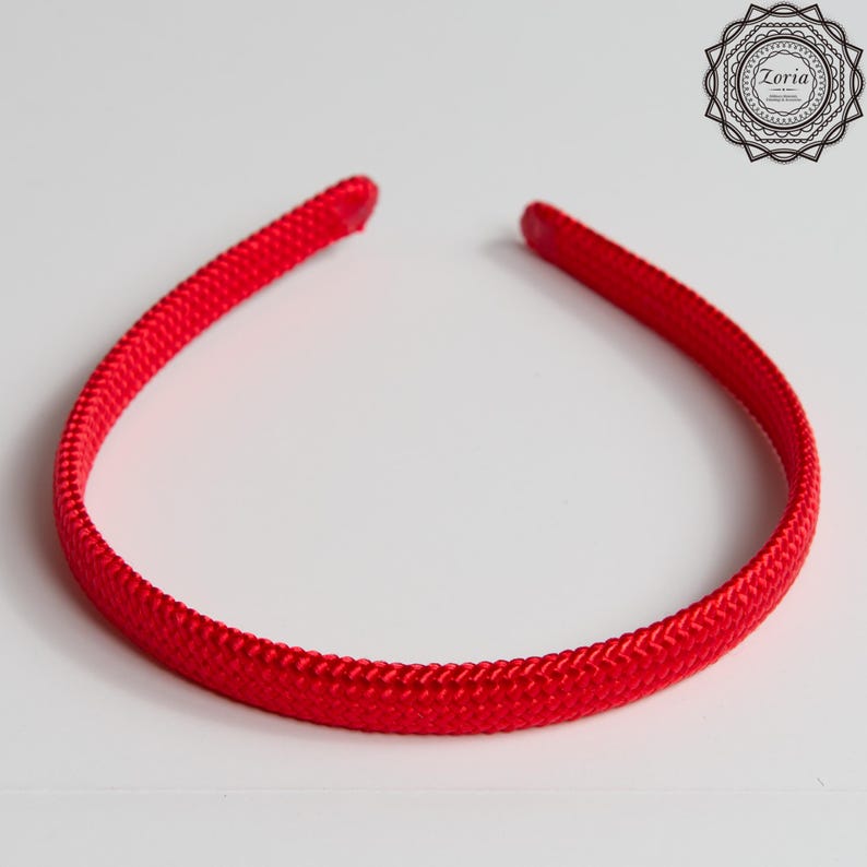 Pu&ograve; includere: Una fascia per capelli rosso brillante con una trama intrecciata. La fascia forma un anello continuo, progettata per essere indossata intorno alla testa. L'accessorio &egrave; di colore pieno e vivace, adatto a vari acconciature e occasioni.