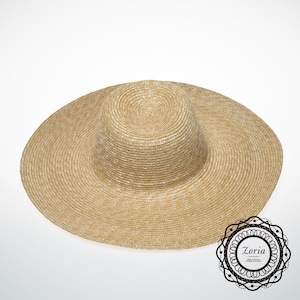 May include: A wide-brimmed straw hat with a light brown color and a woven texture.