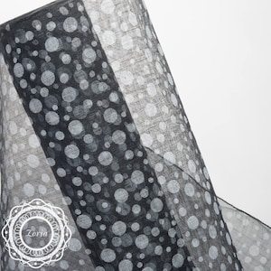 May include: Black sheer fabric with a white polka dot pattern. The fabric is folded in half, showing both sides of the pattern.