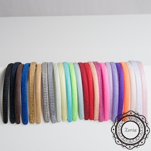 Pu&ograve; includere: Una collezione di fasce colorate in varie tonalit&agrave;, tra cui nero, blu, oro, grigio, bianco, verde, rosso, rosa, viola e arancione. Ogni fascia &egrave; realizzata in materiale tessuto e viene esposta su sfondo bianco.
