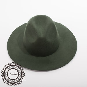 May include: A dark green felt fedora hat with a wide brim.