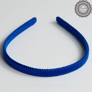 Pu&ograve; includere: Una fascia blu reale con una trama intrecciata. La fascia &egrave; di un colore unico e sembra essere fatta di tessuto. La fascia &egrave; curva e poggia su una superficie bianca. Il logo Zoria si trova nell'angolo in alto a destra.