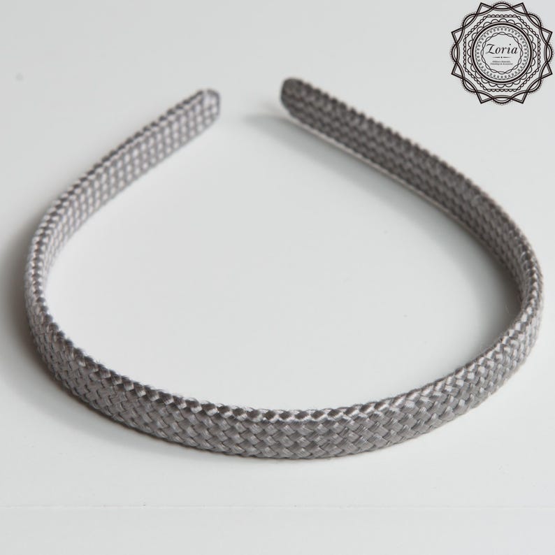 Pu&ograve; includere: Una fascia per capelli grigia intrecciata con un aspetto strutturato. La fascia &egrave; di un colore unico e presenta un design semplice ed elegante. L'accessorio &egrave; adatto a varie acconciature e occasioni.