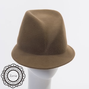 May include: A brown felt fedora hat with a wide brim. The hat is on a white mannequin head.
