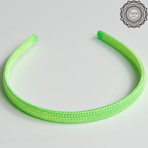 Pu&ograve; includere: Una fascia per capelli verde neon con una trama intrecciata. La fascia &egrave; un anello continuo, progettato per essere indossato intorno alla testa. Il colore brillante e il design semplice lo rendono un accessorio versatile.