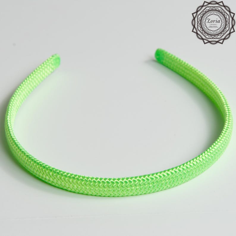 Pu&ograve; includere: Una fascia per capelli verde neon con una trama intrecciata. La fascia &egrave; un anello continuo, progettato per essere indossato intorno alla testa. Il colore brillante e il design semplice lo rendono un accessorio versatile.