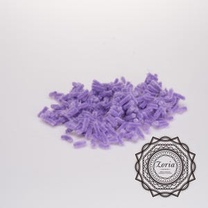 May include: A pile of purple chenille stems, also known as pipe cleaners, on a white background.