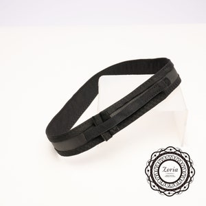 May include: A black fabric belt with a velcro closure and a padded inner layer.