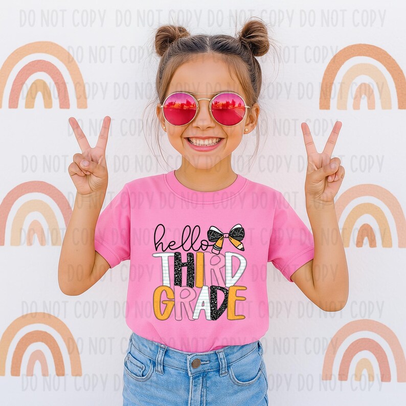 Puede incluir: Una camiseta rosa con las palabras "hello THIRD GRADE" en negro, blanco y amarillo. La camiseta presenta un lazo y un gr&aacute;fico de l&aacute;piz. La persona lleva gafas de sol rosas y hace el signo de la paz.
