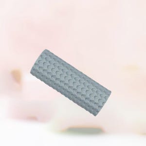 May include: A light gray, rectangular object with a textured surface. The texture is made up of a repeating pattern of curved shapes. The object appears to be made of a soft material.
