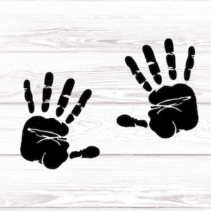 May include: Two black handprints on a white wood background.
