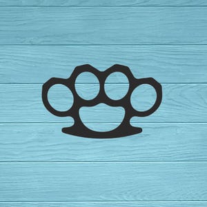 May include: A solid black metal knuckle duster featuring four circular finger holes and a curved palm grip base. The object has a smooth, matte finish and a symmetrical design with a central opening below the finger holes for a secure hold.