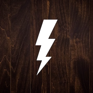 May include: A white lightning bolt shape on a dark brown wood background.