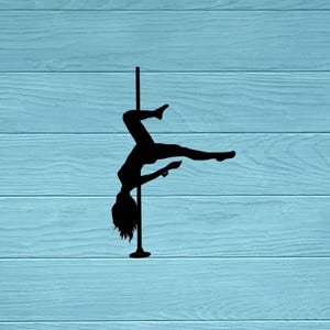 Peut inclure: Silhouette noire d'une personne faisant de la pole dance. La silhouette est à l'envers, les jambes tendues et les bras soutenant le corps sur une barre verticale. Le fond est une surface en bois bleu clair.