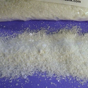May include: A clear plastic bag containing a white powder labeled "TIN MORDANT Stannous Chloride 1 POUND (1 oz.= aprox 3 tsp.) use at 1/2 oz to the pound of fibre wear gloves while handling keep out of reach of children Distributed by www.aurorasilk.com"