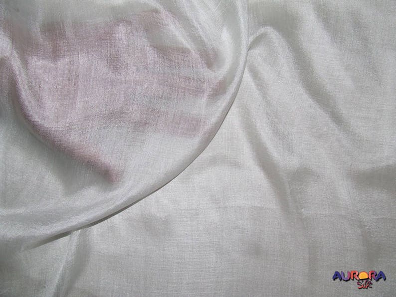 May include: White sheer fabric with a subtle shimmer. The fabric is smooth and drapes beautifully.