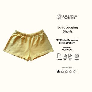 Op de afbeelding: Een gele joggingbroek met elastische tailleband. De afbeelding bevat de tekst "Basic Jogging Shorts" en "PDF Digital Download Sewing Pattern". Het patroon is verkrijgbaar in de maten XS, S, M, L en XL.