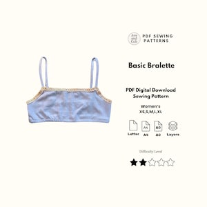 Op de afbeelding: Een lichtblauwe bralette met dunne bandjes en een decoratieve crèmekleurige kanten rand langs de halslijn. De tekst luidt Ave and Coh PDF SEWING PATTERNS, Basic Bralette, PDF Digital Download Sewing Pattern, XS, S, M, L, XL, Letter, A4, A0, Layers.