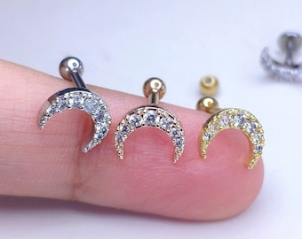 May include: Three silver, gold, and rose gold crescent moon earrings with clear cubic zirconia stones.