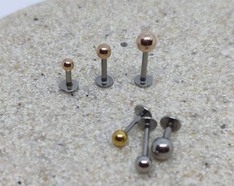 May include: Four different sizes of labret studs with a variety of colors, including gold and rose gold. The studs are made of surgical steel and are suitable for body piercing.