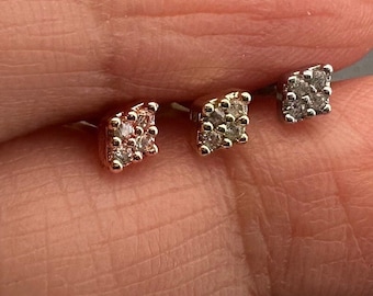 May include: Three pairs of small square diamond earrings in silver, rose gold, and yellow gold.