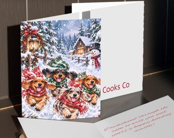 Tarjetas de felicitación navideñas con perros salchicha en un pueblo nevado