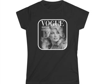 May include: A black short-sleeved t-shirt featuring a white square graphic with rounded corners. The graphic contains a black and white portrait of Dolly Parton with the text VOGUE and DOLLY EDITION printed in white capital letters above her.