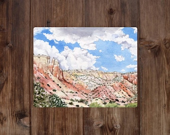 May include: Watercolor painting of a desert landscape with red rock formations and a blue sky with white clouds.