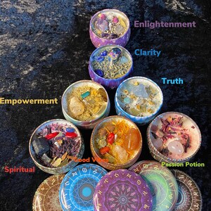 May include: Seven chakra candles in metal tins with various crystals and herbs inside. The lids of the candles feature a mandala design with zodiac symbols. The candles are labeled with the names of the chakras: Root, Sacral, Solar Plexus, Heart, Throat, Third Eye, and Crown.