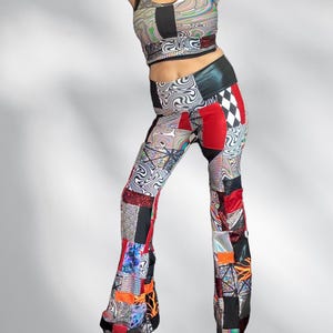 May include: A two-piece outfit featuring a crop top and flared pants. The top has a scoop neck and the pants have a high waist. The outfit is a patchwork of various patterns, including swirls, checkerboard, and geometric shapes, with red, black, and silver accents.