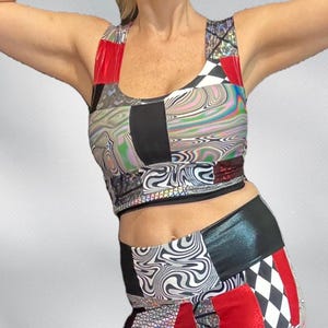 May include: A patchwork crop top and high-waisted bottoms set. The top features red, black, and white panels with a swirling, iridescent pattern. The bottoms have a similar design with a mix of patterns and colors.