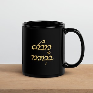 May include: Black ceramic mug with a gold inscription in Elvish script that reads "One Ring to rule them all".
