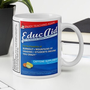 May include: White ceramic mug with a blue and yellow design. The mug features the text "Educ Aid" and "The Medicine for Teachers". The text "For the Prevention of Burnout, Mountains of Grading, Students Driving You Crazy" is also on the mug.