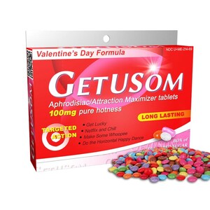 Op de afbeelding: Een rode en witte doos met de tekst "Valentine's Day Formula" en "GETUSOM Aphrodisiac/Attraction Maximizer tablets 100mg pure hotness LONG LASTING" erop. De doos heeft ook een rode cirkel met het woord "TARGETED ACTION" erin. Er liggen kleurrijke, snoep-achtige tabletten verspreid voor de doos.