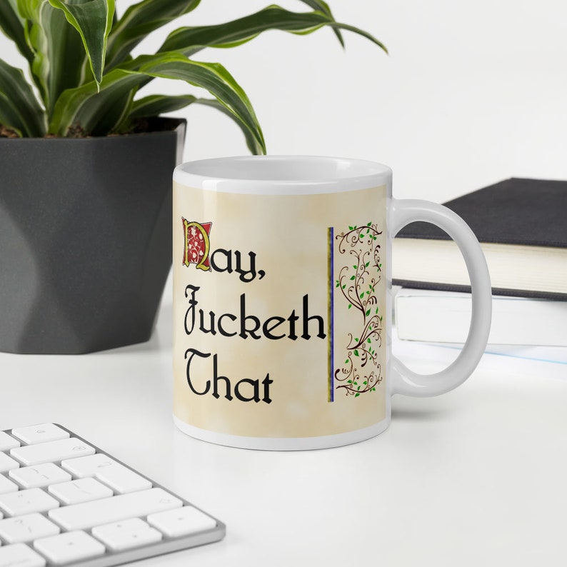 Op de afbeelding: Witte keramische mok met een zwart en gouden ontwerp. De mok heeft een citaat in zwarte letters dat luidt "May, Jucket That".