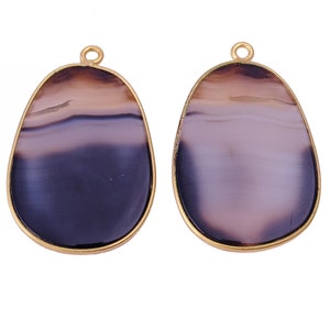 May include: Two gold-rimmed agate pendants with a purple, white, and brown color scheme.