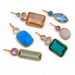 May include: A collection of gold-toned pendants featuring various colorful gemstones. The pendants showcase a variety of shapes, including rectangular, oval, and teardrop, with stones in shades of blue, green, pink, and brown. Each pendant has a loop for hanging.
