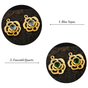 May include: Two gold-colored flower-shaped pendants with a blue gemstone center labeled "1. Blue Topaz". Below, two more gold pendants with a green gemstone center labeled "2. Emerald Quartz".
