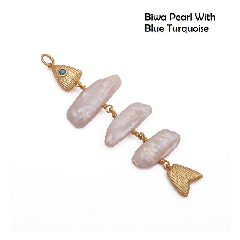 May include: A fish-shaped pendant featuring three elongated, iridescent Biwa pearls linked together. The head is crafted from textured gold-tone metal with a small blue turquoise inlay, and the tail is a matching textured gold-tone metal piece. Text reads: Biwa Pearl With Blue Turquoise.