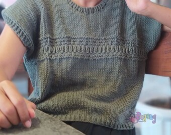 May include: A green knitted sleeveless top with a round neckline and a decorative pattern around the waist.