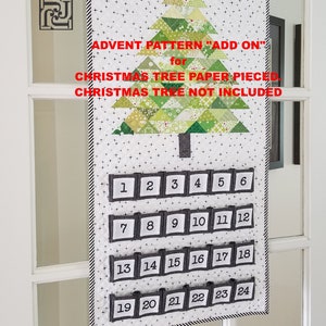 Peut inclure: Un calendrier de l'avent en tissu blanc avec un motif d'arbre de Noël en papier découpé vert et blanc. Le calendrier comporte 24 poches numérotées pour des friandises quotidiennes. Le texte "ADVENT PATTERN "ADD ON" for CHRISTMAS TREE PAPER PIECED. CHRISTMAS TREE NOT INCLUDED." est imprimé sur le tissu.