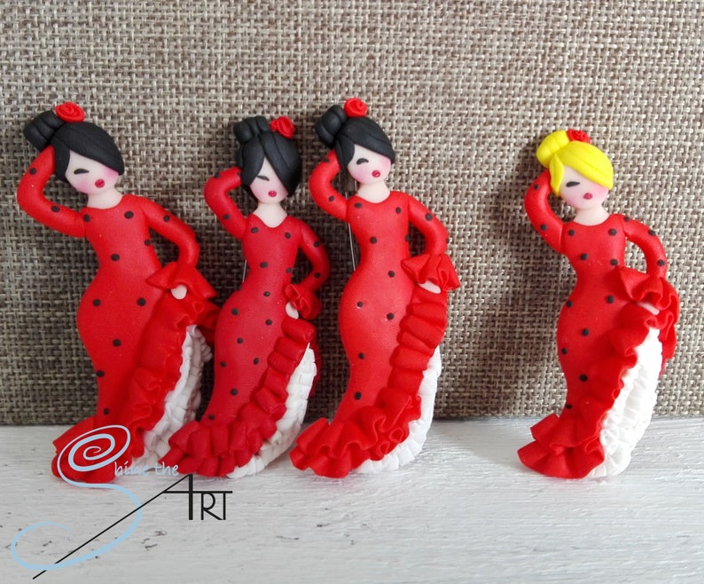 May include: Four handmade red and black polka dot flamenco dancer figurines. Each figurine has a white ruffled skirt and black hair. One figurine has yellow hair.
