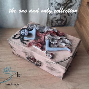 The sleeping CORPSE BRIDE handmade in polymer clay on a cardboard pink box
