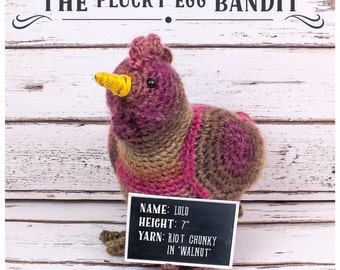 May include: A crocheted chicken amigurumi toy with a yellow beak and brown, pink, and orange yarn. The toy is 7 inches tall and is labelled "LULU" with the yarn type and colour.