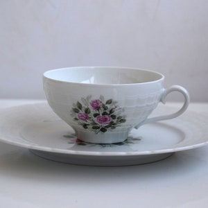 Könnte beinhalten: Ein weißes Tee-Set mit einem Blumendesign mit rosa Rosen und grünen Blättern.