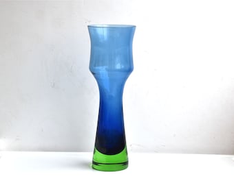Könnte beinhalten: Eine blaue und grüne Glasvase mit einem ausgestellten oberen Teil und einer schmalen Basis.