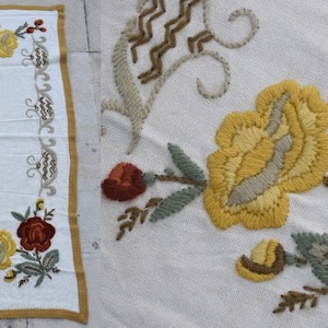Könnte beinhalten: Ein weißer bestickter Läufer mit goldener Bordüre und Blumendesigns. Der Läufer zeigt gelbe, orange und grüne Blumen.