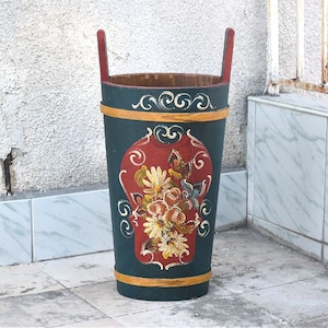 Può includere: Un alto portaombrelli in legno dipinto di blu e verde con un motivo floreale. Il portaombrelli ha un motivo floreale rosso, giallo e bianco con un uccello al centro.